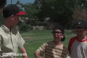 A Group Of Boys Are Standing In A Grassy Field And One Of Them Is Wearing A Ny Hat GIF