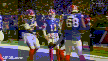 A Group Of Buffalo Bills Football Players Are Standing On The Field . GIF