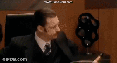 A Group Of Business People Are Sitting Around A Table In A Conference Room Having A Meeting . GIF