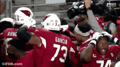 A Group Of Cardinals Football Players Huddled Together GIF