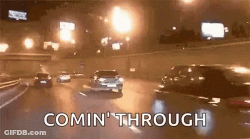 A Group Of Cars Are Driving Down A Highway At Night And The Words Comin ' Through Are Visible . GIF