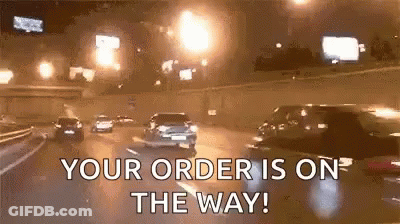 A Group Of Cars Are Driving Down A Highway At Night With The Words `` Your Order Is On The Way '' . GIF