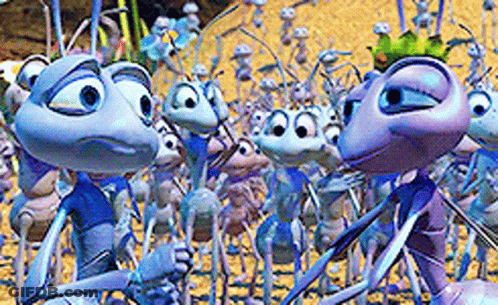 A Group Of Cartoon Ants Are Standing In The Sand GIF