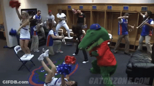 A Group Of Cheerleaders Are Dancing In A Locker Room With Gatorzone.com Written On The Bottom GIF