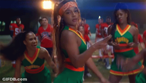 A Group Of Cheerleaders Are Dancing In Front Of A Group Of Football Players One Of Whom Is Wearing Number 38 GIF