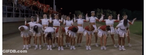 A Group Of Cheerleaders Are Posing For A Picture With Their Arms In The Air GIF