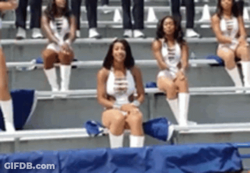 A Group Of Cheerleaders Are Sitting On A Bench In The Stands GIF