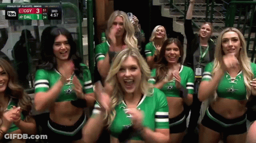 A Group Of Cheerleaders Are Standing In Front Of A Scoreboard Which Says Stanley Cup Playoffs On It GIF