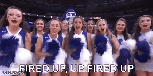 A Group Of Cheerleaders Are Standing Next To Each Other On A Basketball Court With A Mascot . GIF