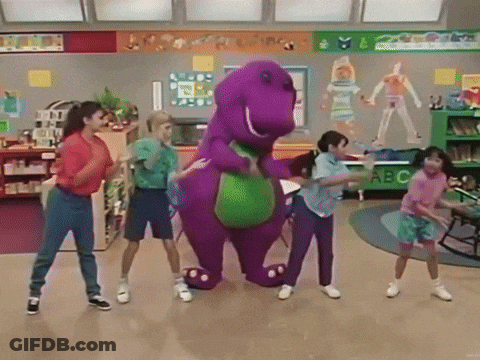 A Group Of Children Are Dancing Around A Purple Dinosaur In A Classroom With A Sign That Says Abc GIF