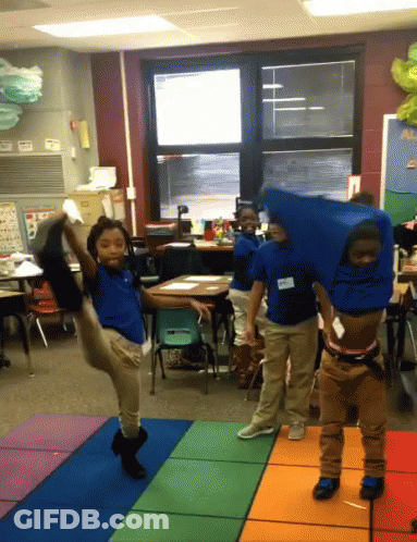 A Group Of Children Are Dancing In A Classroom With One Wearing A Name Tag That Says ' Amanda ' On It GIF