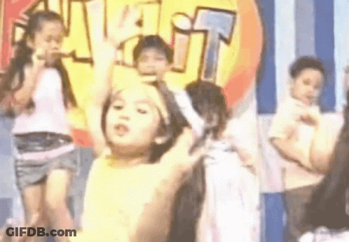 A Group Of Children Are Dancing On A Stage In Front Of A Sign That Says Visit . GIF
