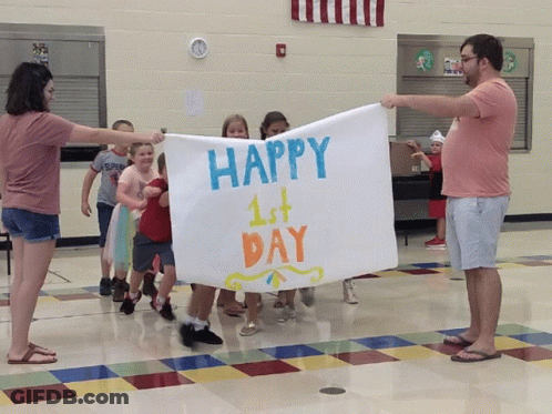 A Group Of Children Are Holding Up A Sign That Says Happy 1St Day GIF
