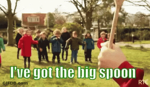 A Group Of Children Are Playing In A Park With A Person Holding A Big Spoon In Front Of Them . GIF