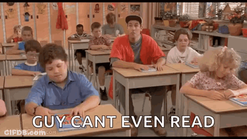 A Group Of Children Are Sitting At Desks In A Classroom With A Man Standing In The Middle Of The Room . GIF