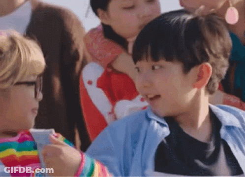 A Group Of Children Are Sitting In A Stadium Watching A Game . GIF