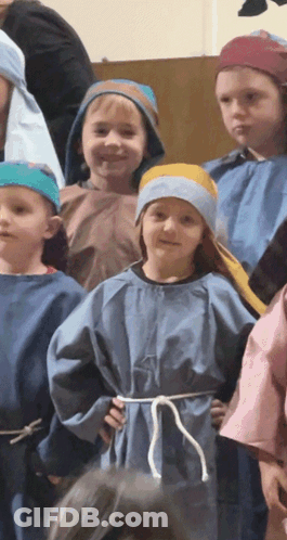 A Group Of Children Dressed In Blue Robes And Blue Hats GIF