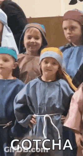 A Group Of Children Dressed In Costumes Are Standing Next To Each Other And One Of Them Is Wearing A Blue Robe . GIF