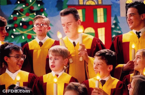 A Group Of Children Singing In A Choir With Candles In Their Hands GIF