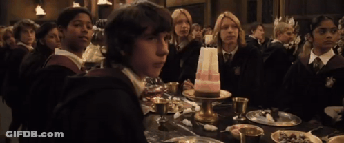 A Group Of Children Sit At A Table With A Cake On It GIF