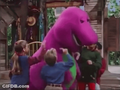 A Group Of Children Standing Around A Purple And Green Dinosaur . GIF
