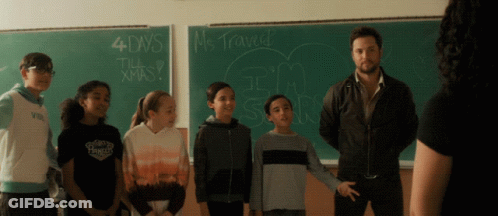 A Group Of Children Standing In Front Of A Blackboard That Says 4 Days Till Christmas GIF