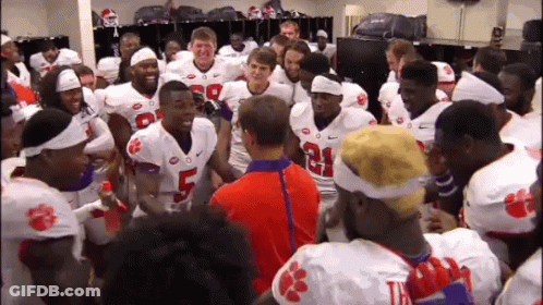 A Group Of Clemson Football Players Huddle Together In The Locker Room GIF