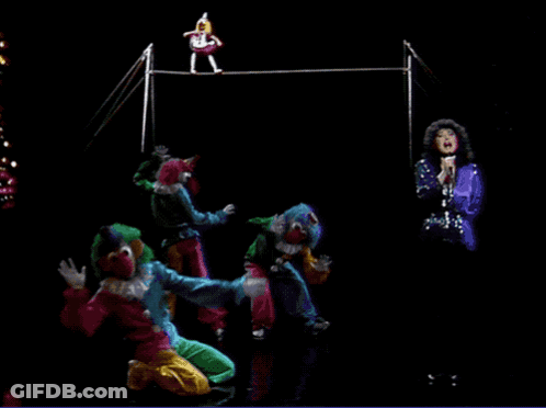 A Group Of Clowns Performing On A Stage With A Woman Singing In The Background GIF