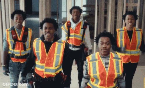A Group Of Construction Workers Wearing Orange Vests Are Standing Together GIF