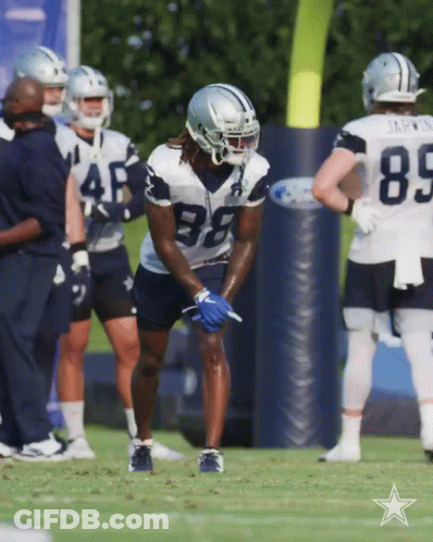 A Group Of Cowboys Players Are Standing On The Field GIF