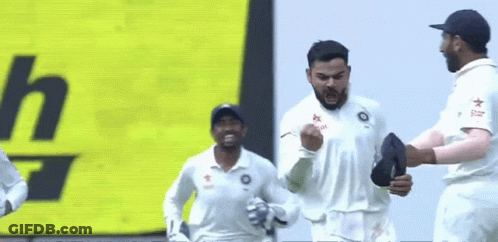 A Group Of Cricket Players Are Celebrating A Win In Front Of A Yellow Sign . GIF