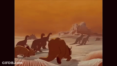 A Group Of Dinosaurs Are Walking Across A Desert Landscape . GIF