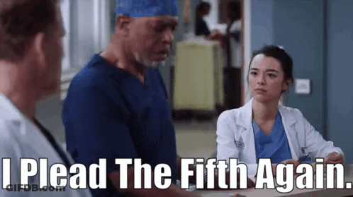 A Group Of Doctors Are Standing In A Hospital Lobby And One Of Them Is Talking To Another Doctor . GIF