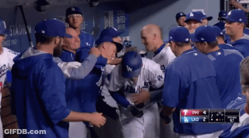 A Group Of Dodgers Baseball Players Are Gathered In The Dugout GIF