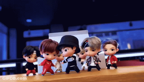A Group Of Dolls Are Dancing Together On A Table GIF