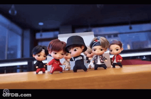 A Group Of Dolls Are Standing On A Table And One Of Them Is Wearing A Hat GIF