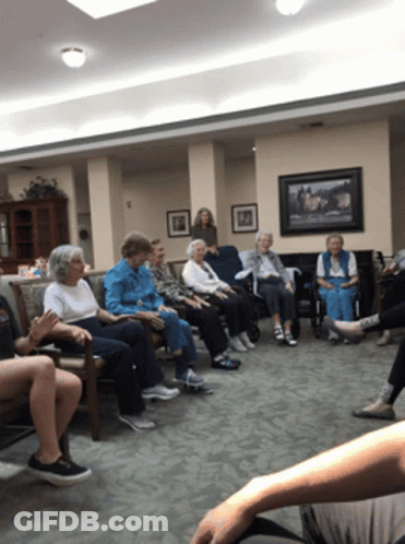 A Group Of Elderly People Are Sitting In A Circle GIF