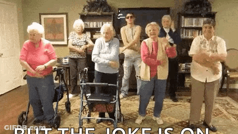A Group Of Elderly People Are Standing In A Living Room Dancing . GIF