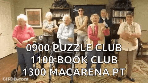 A Group Of Elderly People Are Standing In A Room . GIF