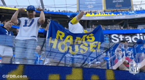 A Group Of Fans Are Standing In A Stadium Holding A Banner That Says Rams House . GIF