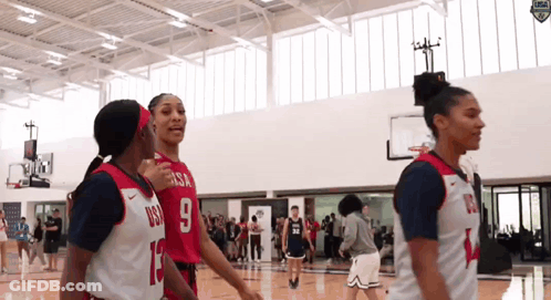 A Group Of Female Basketball Players Are Standing On A Court And One Has The Number 9 On Her Jersey GIF