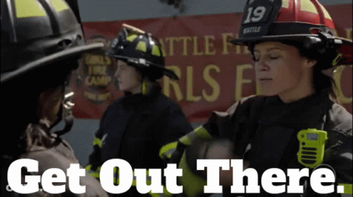 A Group Of Firefighters Standing In Front Of A Banner That Says Get Out There GIF