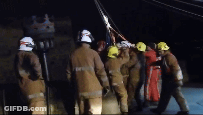 A Group Of Firefighters Wearing Yellow Helmets Are Standing In A Line GIF