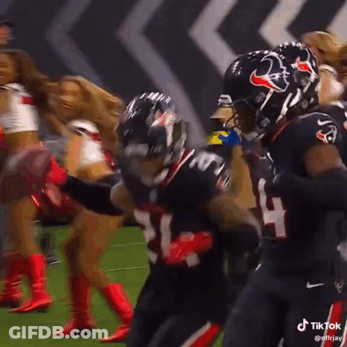A Group Of Football Players Are Celebrating A Touchdown On A Field . GIF