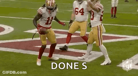 A Group Of Football Players Are Celebrating A Touchdown On A Football Field . GIF