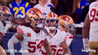 A Group Of Football Players Are Celebrating A Touchdown . GIF