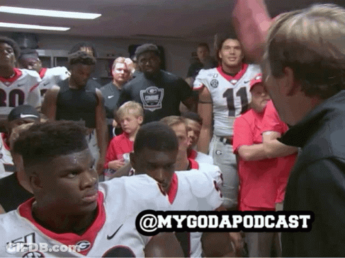 A Group Of Football Players Are Gathered In A Locker Room With The Hashtag @Mygodapodcast GIF