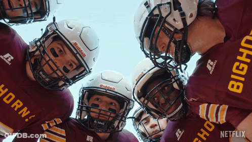 A Group Of Football Players Are Huddled Together With One Wearing A Red Jersey That Says Horn GIF