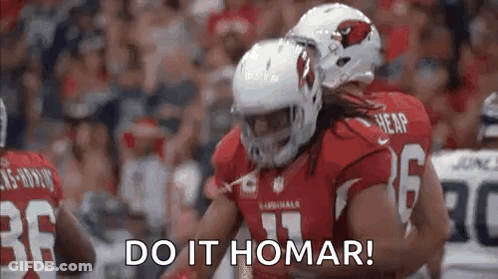 A Group Of Football Players Are Hugging Each Other On A Field . GIF