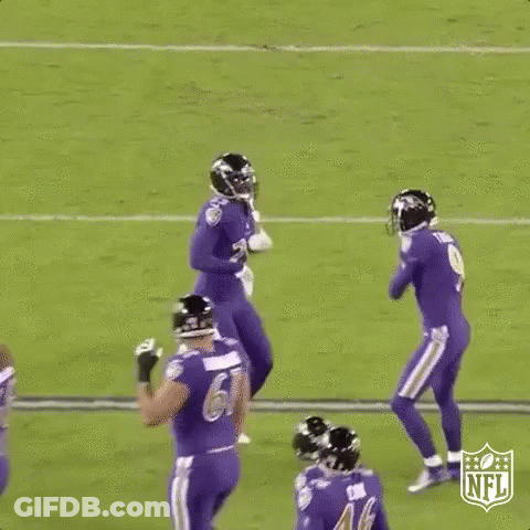 A Group Of Football Players Are Jumping In The Air On A Field During A Game . GIF